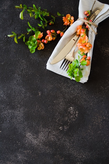 Vintage table setting with delicate flowers on a dark background