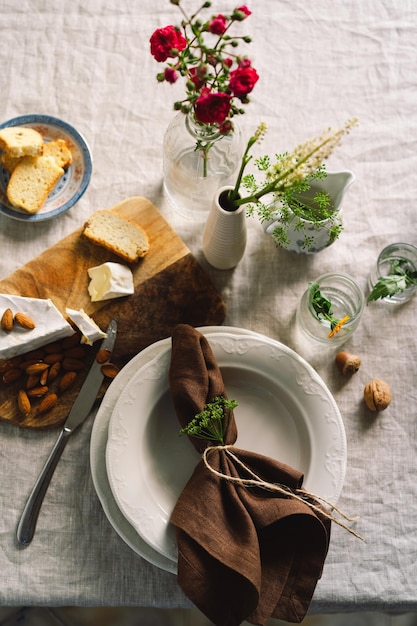 Vintage table setting with Linen napkins and floral decorations Close up Cozy calm meal in the morning in the sunshine