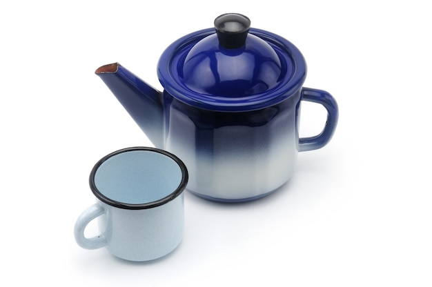 Vintage teapot in blue with a mug on an isolated white