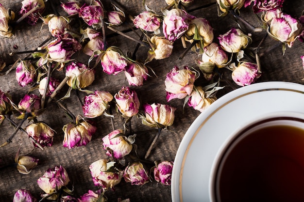 Vintage teapot and cup with blooming tea flowers on wood