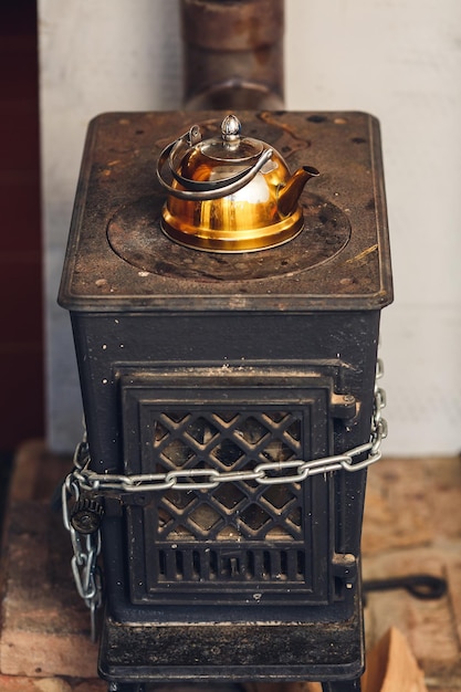 Vintage teapot of golden color stands on stove.