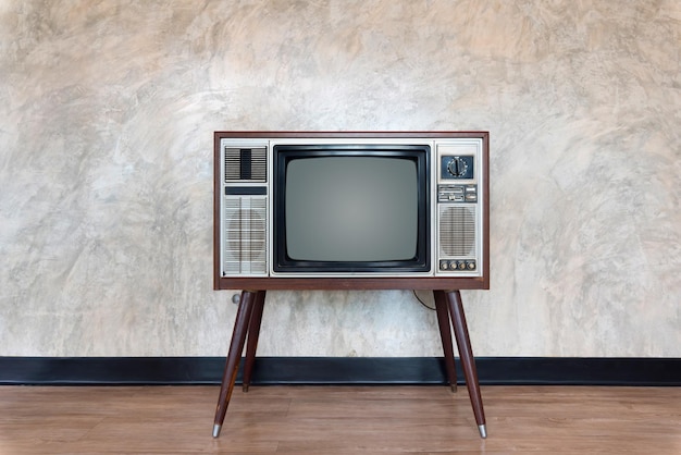 Photo vintage television set on floor against wall