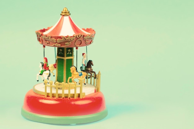 Vintage toy carousel on an emerald background Red carillon with carousel retro carousel