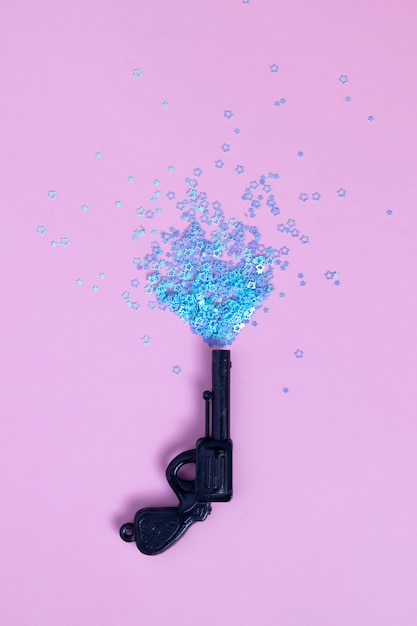 Foto sparare a pistola giocattolo vintage con mini stelle blu su rosa