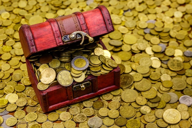 Vintage treasure chest full of gold coins on a background of golden coins