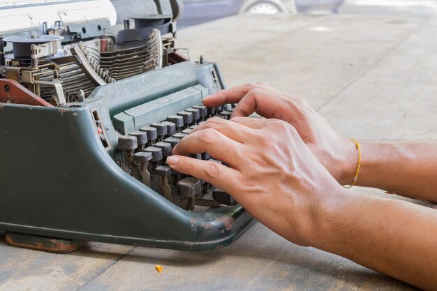 Photo vintage typewriter and human hand on a wood table