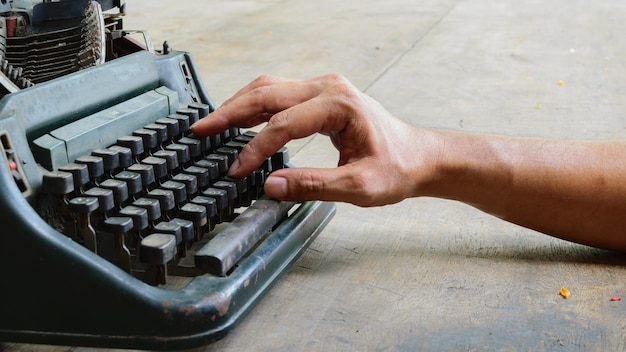 Vintage typewriter and human hand on a wood table