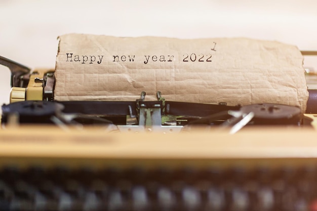 Vintage typewriter with a brown sheet of paper and Happy new year 2022