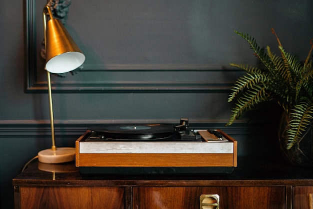 Vintage vinyl platenspeler in een stijlvol interieur een gouden kaars en groene kamerplanten