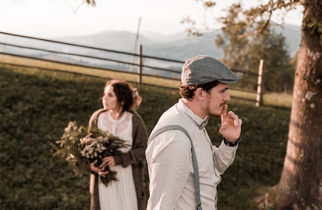 Matrimonio vintage della sposa e dello sposo in un ranch con un cavallo sulle colline a picco