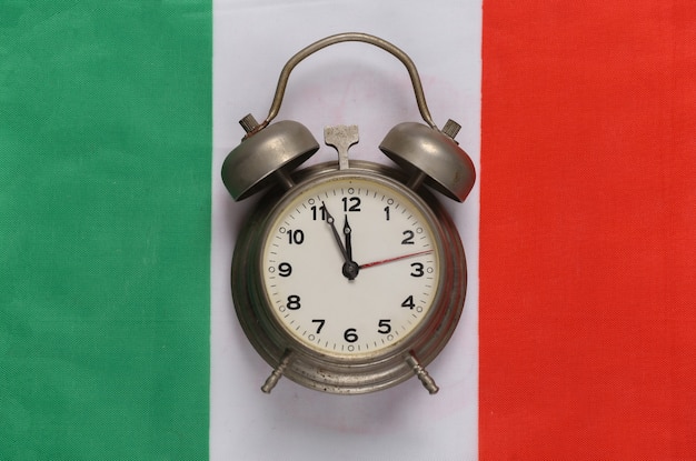 Vintage wekker op de achtergrond van de vlag van Italië