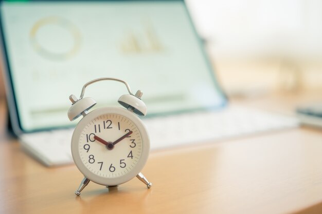 Vintage White Alarm Clock on on a NoteBook. It's time to rest.