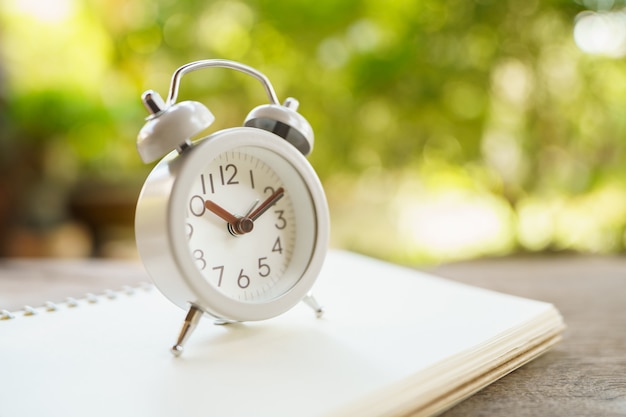 Vintage White Alarm Clock on wood. It's time to rest.