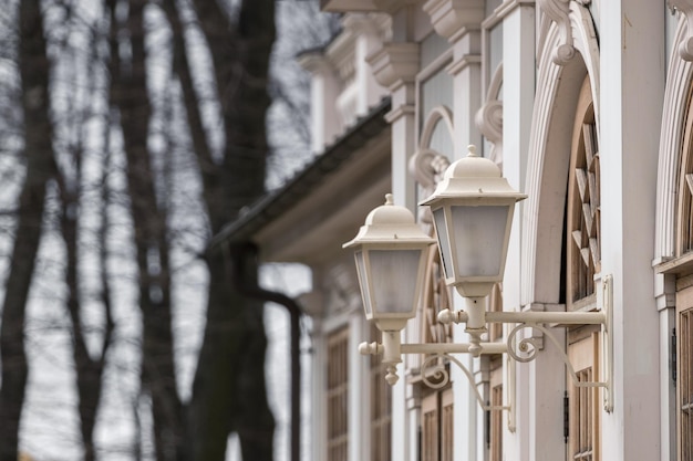 Vintage white street lighting lanterns on the facade of a historic building