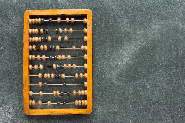 Photo vintage wooden abacus on smudged chalkboard