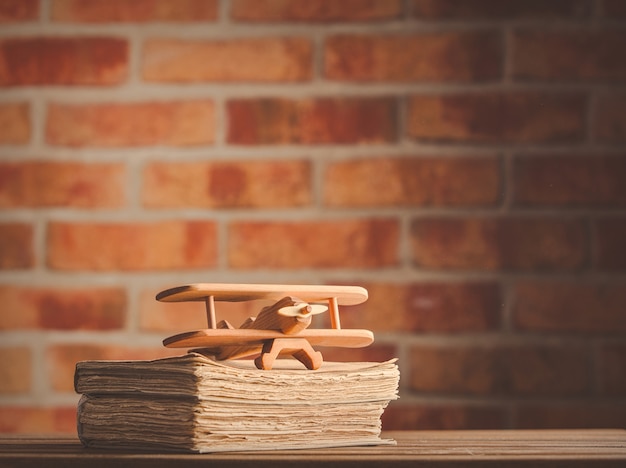 Vintage wooden airplane toy and old books