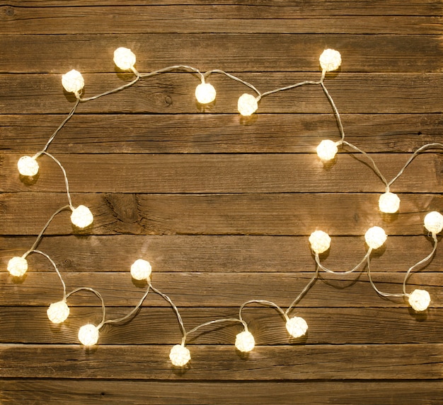 Vintage wooden background framed by garlands of rattan lanterns. Top view