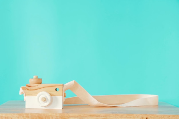 Vintage wooden camera toy over blue background with copy space.