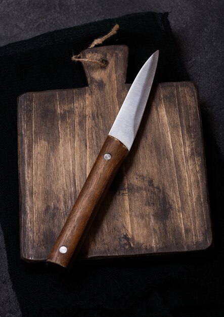 Vintage wooden cutting board with towel and knife. Kitchen cooking concept.