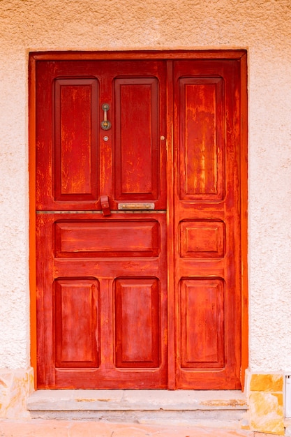 スペインの村のヴィンテージの木製の赤いドア