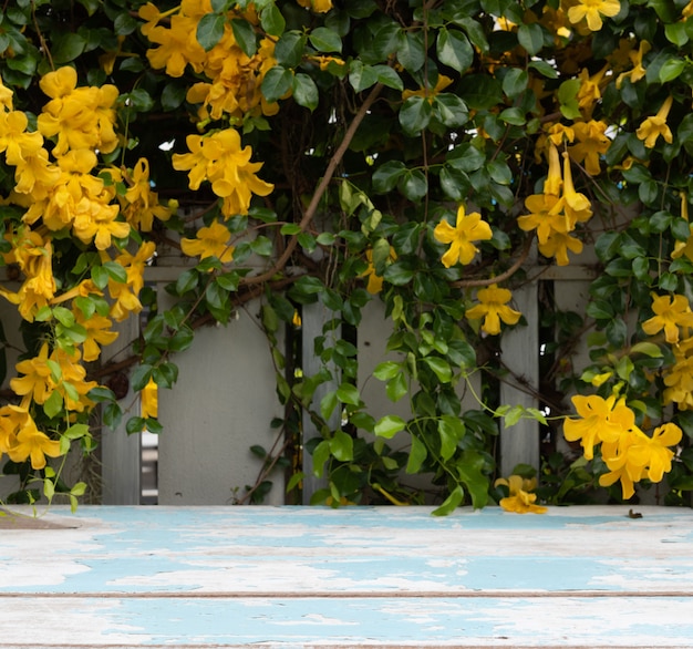 Ripiano del tavolo in legno d'epoca con bellissimi fiori gialli e foglie verdi