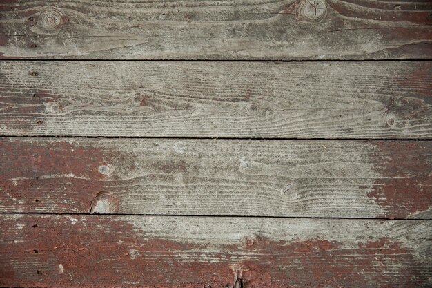 Vintage wooden texture with remnants of a peeling old red paint Old wood background