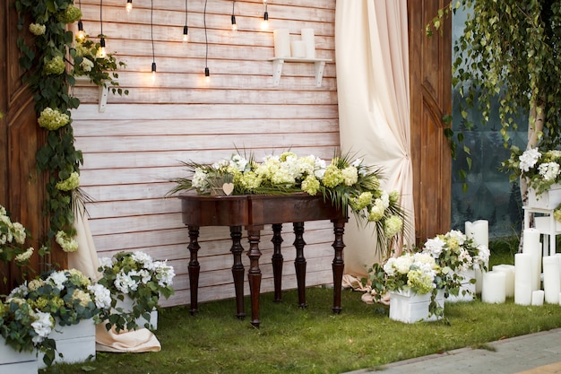 Vintage wooden wedding decoration for wedding ceremony with green leaves and flowers