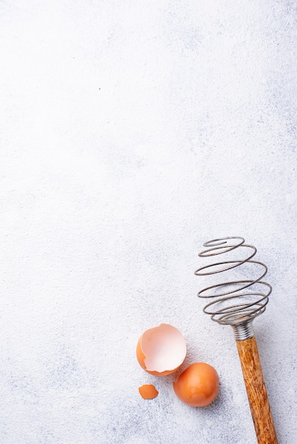 Vintage wooden whisk and eggshells