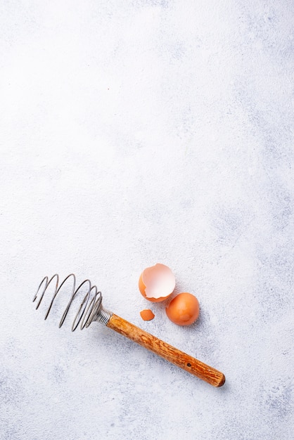 Vintage wooden whisk and eggshells