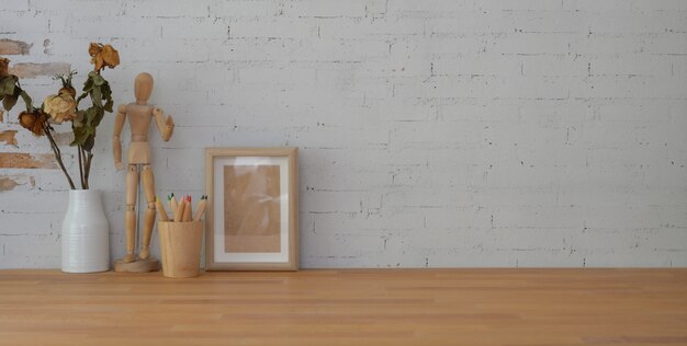 vintage workplace with mock up frame and copy space on wooden table and brick wall