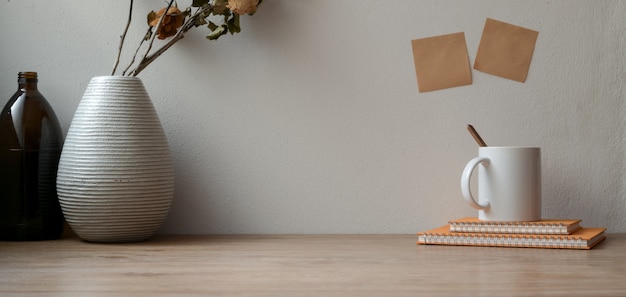 Vintage workspace with dry roses with office supplies and copy space on wooden table and sticky note