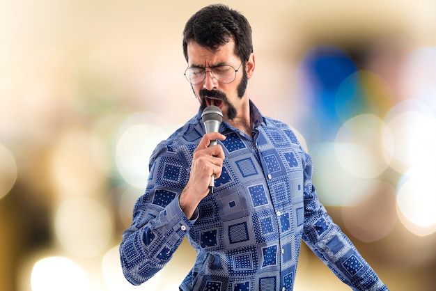 Vintage young man singing with microphone  on unfocused background