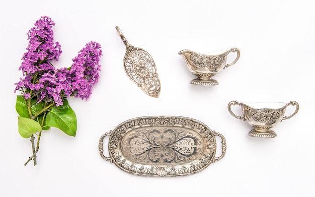 Vintgae silver dishes and lilac flowers Flat lay