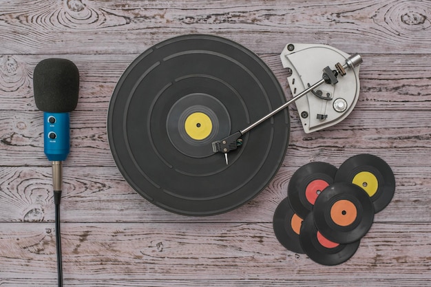 Photo vinyl discs, a player and a microphone on a wooden background. retro technique for playing music.