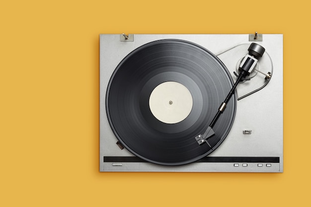 Photo vinyl player with long play or lp record on yellow background. top view, copy space.