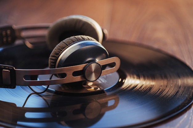 Vinylplaat en hoofdtelefoon over houten tafel. Audio-enthousiast, muziekliefhebber of professionele disc jockey-apparatuur.