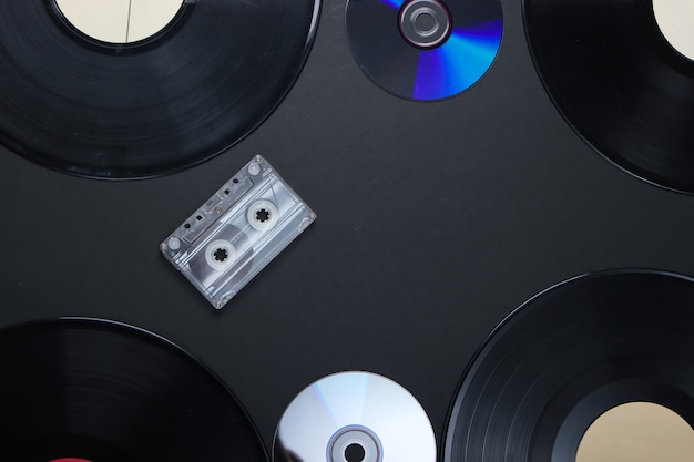 Vinylplaten, audiocassette en cd-schijven op zwart oppervlak