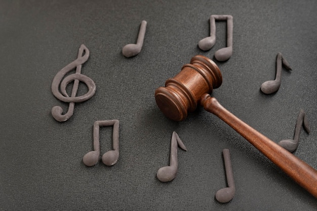 Violation of music license and copyright. Judges gavel surrounded by treble clef and notes on black background. Music piracy.