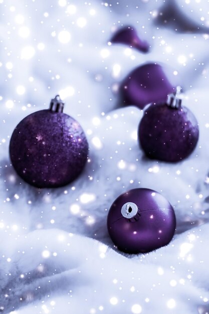 Violet Christmas baubles on fluffy fur with snow glitter luxury winter holiday design background