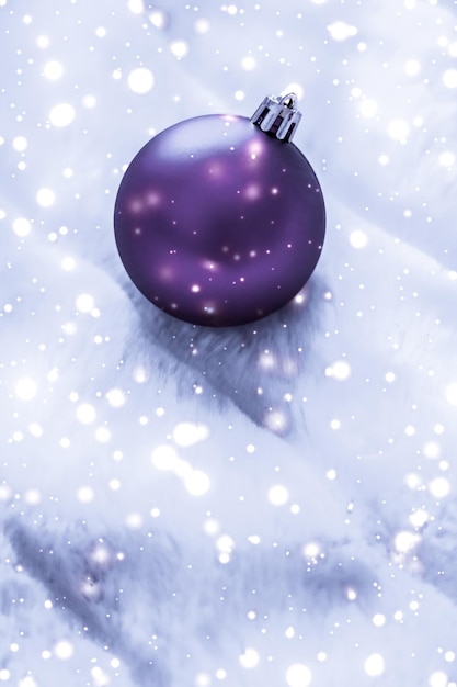 Violet kerstballen op pluizige vacht met sneeuw glitter luxe wintervakantie ontwerp achtergrond