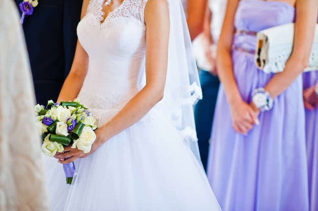 花嫁の背景新郎と新婦付け添人の手に紫のウェディングブーケ