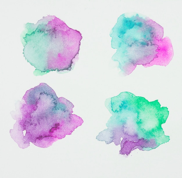 Violette en groene verfvlekken op wit papier