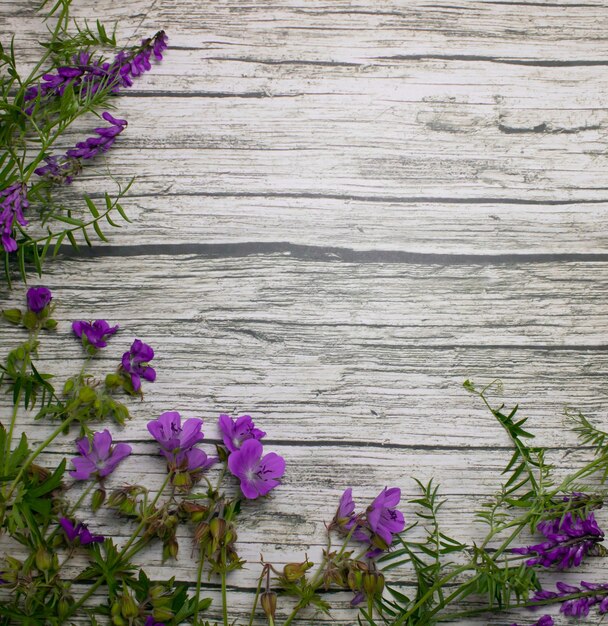 Violette natuurlijke wilde bloemen op een houten achtergrondruimte voor tekst