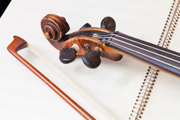 Foto arco di violino e scorrere sul libro di musica