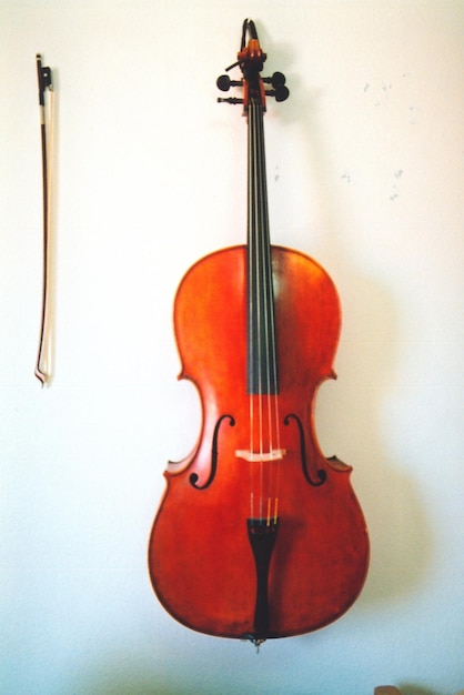 Foto il violino appeso al muro bianco