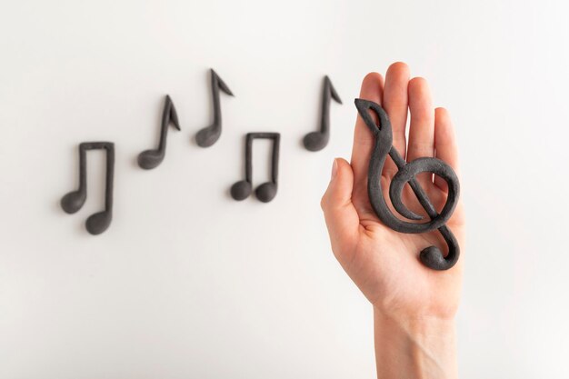 Violin key on the palm of your hand on notes background. Treble clef and notes on white background. Music symbol.