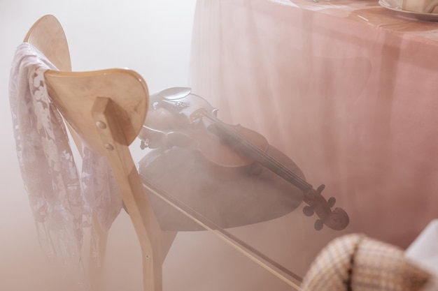 Violin lies on a chair in a banquet hall in the fog