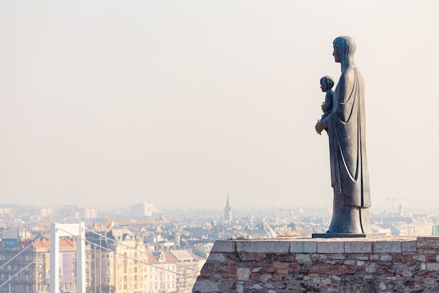 Statua di vergine maria e la vista della città di budapest, ungheria