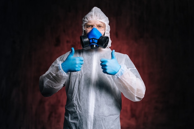 Virologist in hazmat goggles and respirator is showing double thumbs up gesture