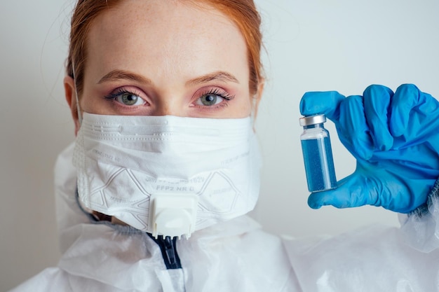 Donna virologa in maschera di protezione chimica occhiali e guanti con potenziale vaccino in laboratorio